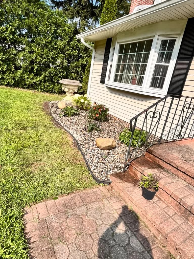 Front walkway beside a finished decorative stone garden and planting bed