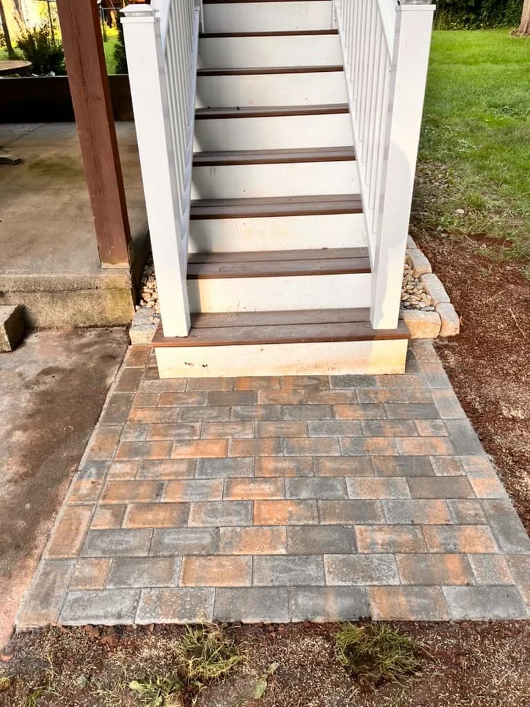 Small paver landing installed at the base of residential outdoor steps